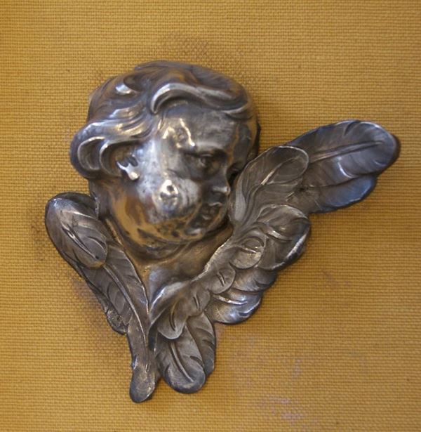 Testa di cherubino, sec. XIX, in argento, cm 10x11