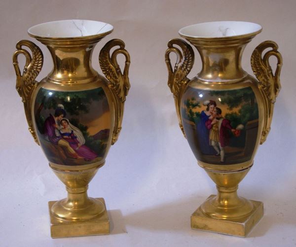 Coppia di vasi, Francia, sec. XIX, in porcellana decorata a figure, con manici a forma di cigno, cm 32  uno restaurato(2)