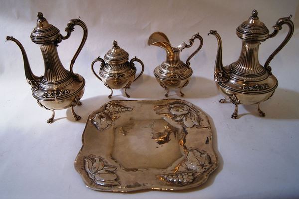 Quattro pezzi, in particolare lattiera, teiera, caffettiera e zuccheriera, in argento lavorato e cesellato, e Vassoio, in argento, tot. gr. 3250(5)