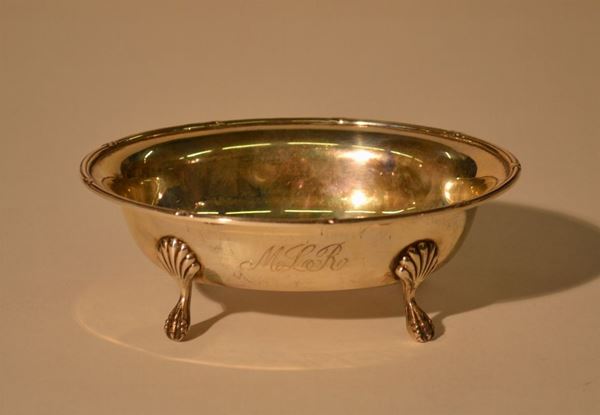 Vaschetta, sec. XX, di forma ovale in argento, bordo rigato e intercalato   da nastri, poggiante su quattro piedini,  cm 16x12,5, g 175