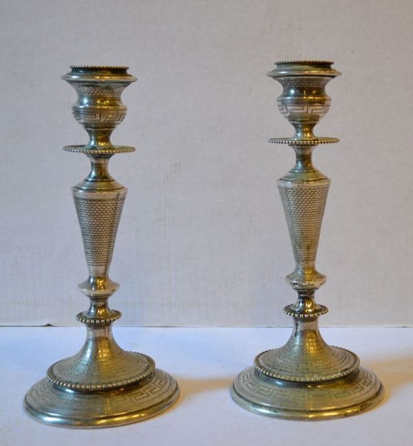 Coppia di candelabri, sec. XIX,  in argento, lavorazione a villoche, base   circolare incisa a greca, alt. cm 21.5, g 375 (2)