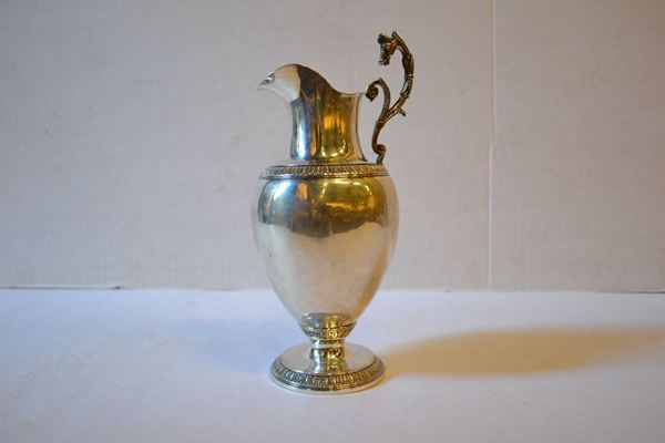 Versatoio in argento, base circolare con decorazioni a palmette, corpo      liscio ovoidale,decorato a palmette, alt. cm 19, g 200