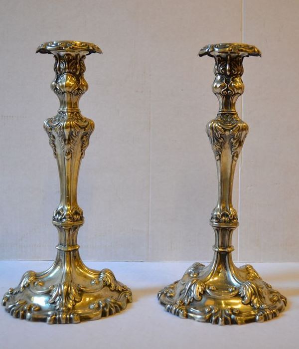 Coppia di candelieri in argento, base sagomata, sbalzata a fogliame, fusto  troncopiramidali con decori vegetali, alt. cm 27, g 500 (2)
