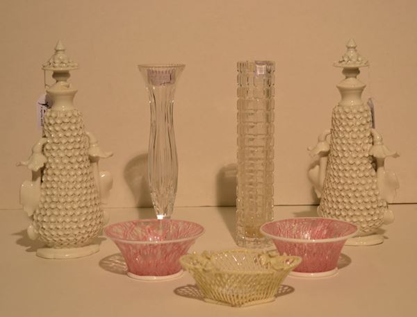 Coppia di coppette, in vetro a reticolo rosa decorate da due placchette in  ceramica bianca con stemmi, diam. cm 12; vaschetta, in ceramica bianca      lavorata come un cestino con fiori sul bordo, cm 13x10; coppia di vasetti   con coperchio, in porcellana bianca decorata da fiori in rilievo che        incorniciano mazzetti di fiori policromi, alt. cm 28 e due vasetti          portafiori in cristallo, alt. cm 24,5 e 25 lievi danni (7)