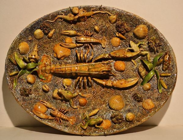 Piatto, Francia, sec. XX, in terracotta alla maniera di Palissy, con pesci  e anfibi in rilievo, cm 62x47, felatura