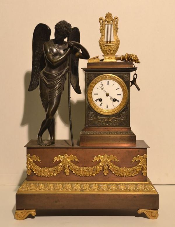 Orologio da tavolo, Francia, sec. XIX, in metallo e bronzo, cassa           affiancata da Cupido con cetra, alt. cm 52, meccanismo da riparare