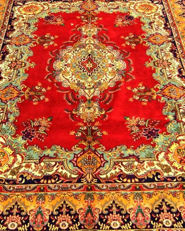 Tappeto persiano tabriz, di vecchia manifattura a motivo floreale, fondo rosso con grande medaglione centrale e bordura in blu, rosso e beige, cm 410x295