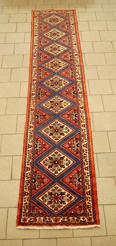 Tappeto persiano rudbar, campo a motivo geometrico e fiori stilizzati, fondo rosso con diversi medaglioni multicolore, cm 390x75