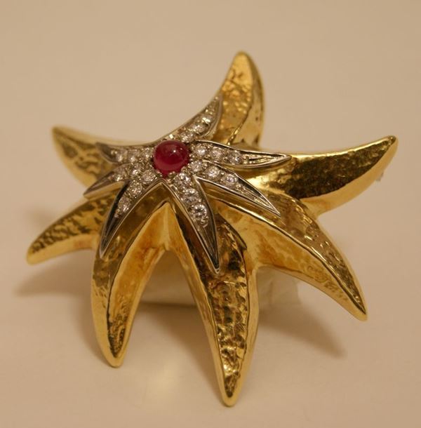 Spilla, STELLA MARINA, in oro giallo e bianco, con decorazione a rubino cabouchon e brillanti, ct 0,70, gr. 23