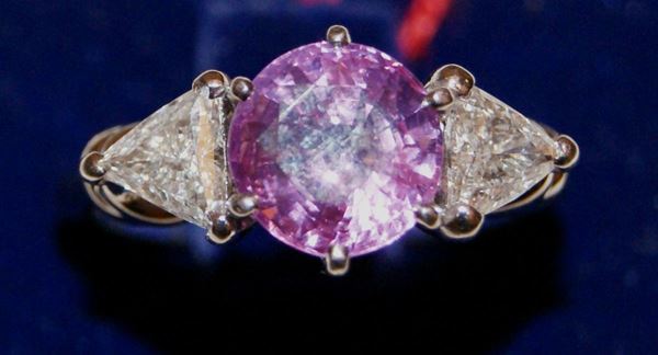Anello, in oro bianco, con pietra di colore centrale di taglio brillante e due brillanti di taglio triangolare, ct 0,96, gr. 5,8