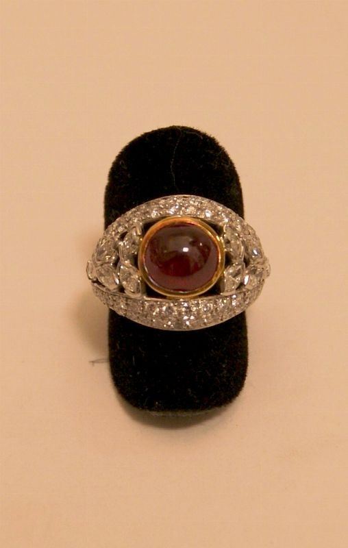Anello, in oro bianco e giallo, con rubino centrale cabouchon e pave' di brillanti di vari tagli, marcato Torrini, gr. 7,20
