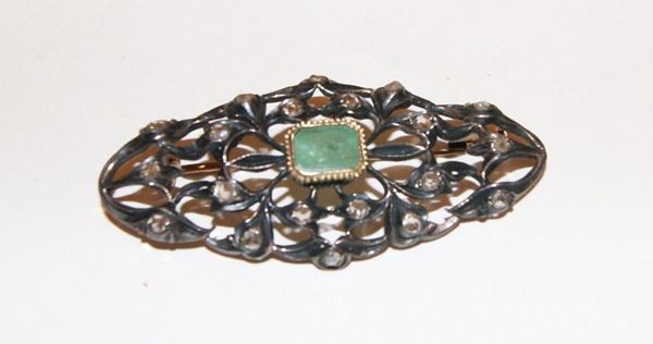 Spilla, inizi sec. XX, in oro basso e argento, con smeraldo centrale rettangolare e diamanti