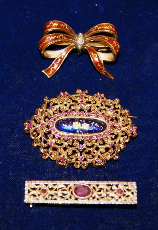 Spilla, in oro giallo traforato, con decorazione a smalti e piccoli rubini, Spilla a barra, in oro giallo, traforato con rubini, e Spilla a fiocco, sec. XIX, in oro giallo, con brillantini e smalti, tot. gr. 29 (3)