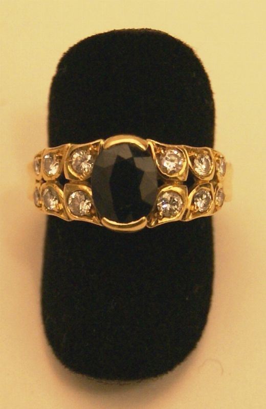 Anello, in oro giallo con zaffiro e dodici brillanti laterali, gr. 6,7