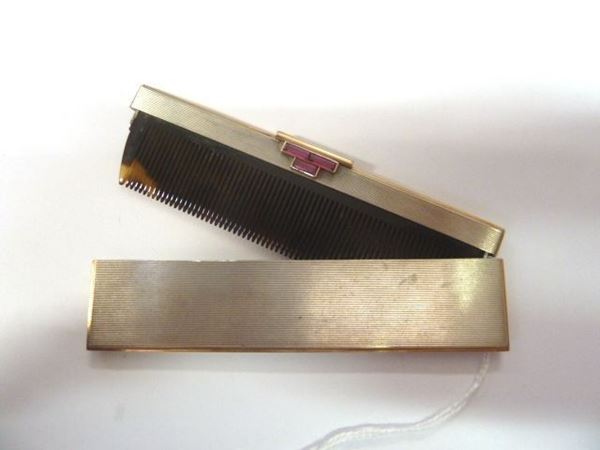 Pettine da borsetta, inizi sec. XX, in tartaruga, argento, oro giallo e rubini sintetici pettine in tartaruga con montatura in argento inciso a rigature e profilato in oro giallo, apertura decorata da tre rubini sintetici baguette, g 60 lordi