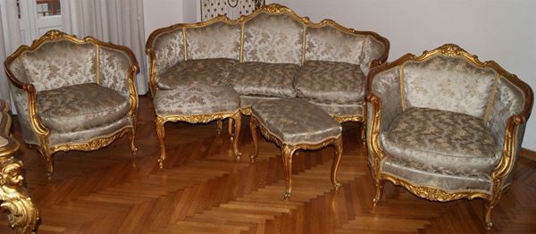 Salotto, primi sec. XX, composto da divano, due poltrone e due panchetti, in legno intagliato e dorato, imbottite e ricoperte in stoffa decorata a fiori
