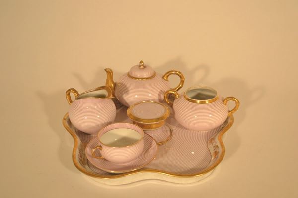 Servito tÃ¨te a tÃ¨te, sec. XX, in porcellana decorata da filature concentriche in rosa scuro e bordi dorati, composto da: vassoio ondulato, teiera con coperchio, lattiera e una tazza con piattino, mancante di una tazza(5)