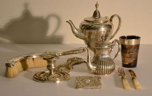 Caffettiera in argento, Londra 1883, in argento, corpo inciso a festoni, g  360; spazzola, con manico in argento, Inghilterra, epoca Liberty;           caffettiera 'egoiste', in argento, sec. XX, g 170; coltello e forchetta,    Parigi, sec. XIX, in vermeille e madreperla; portabiglietti, Inghilterra,   sec. XIX, in argento, g 50; bicchiere, Inghilterra, sec. XIX, in corno con  montatura in argento ed una bugia in rame argentato, sec. XIX (8)