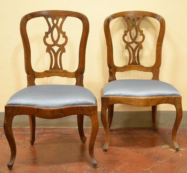 Coppia di sedie, Toscana fine sec. XVIII, in noce intagliato, cartella      traforata a vaso, gambe mosse; ed un panchetto in stile Settecento in noce  con gambe sagomate a volute, ricoperto in lampasso (3)