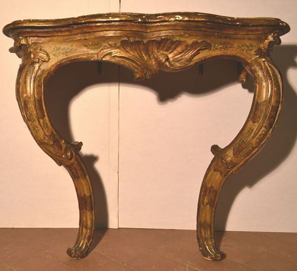Piccola console, sec. XVIII, in legno intagliato dorato e dipinto a motivi  fogliacei, piano sagomato sostituito, gambe mosse, restauri, cm 92x53x85