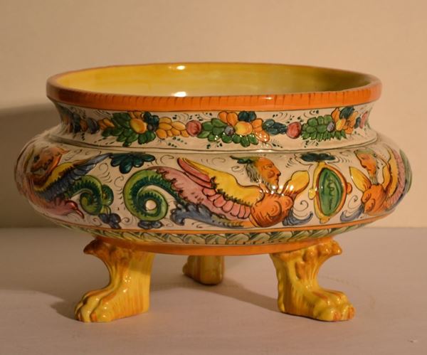 Coppa, sec. XX, di forma circolare in ceramica policroma decorata da        festoni di frutta ed animali fantastici, tre piedini modellati a zampa      ferina, diam. cm 23,5