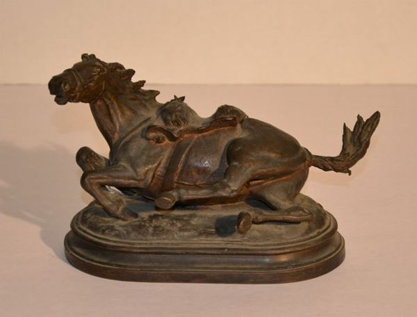 Piccola scultura, Fonderia Cappellini, Pistoia sec. XIX, in bronzo a patina scura modellata come un cavallo a terra sellato per la battaglia su base in bronzo di forma ovale gradinata, alt. cm 14,5