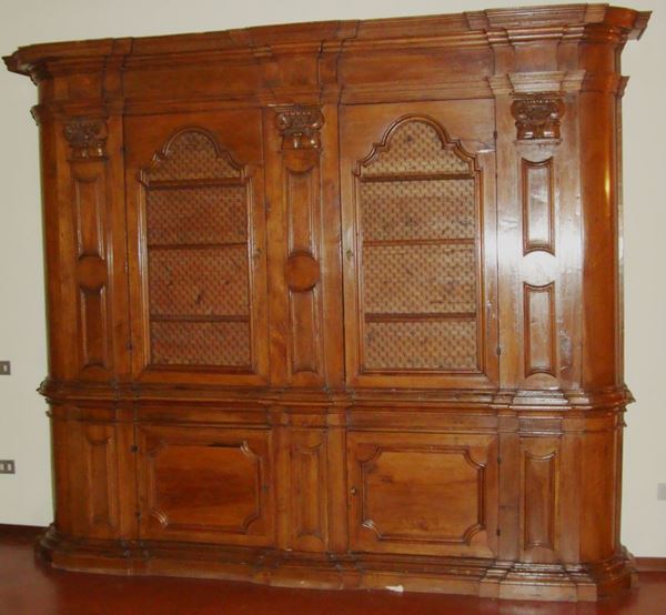 Libreria, Veneto, sec. XVIII, in noce intagliato, a quattro sportelli e sei sportellini alle colonne, cm 310x44x255