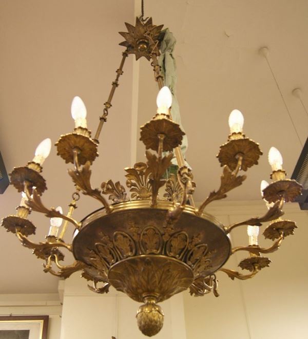 Lampadario, in stile Impero, a dodici luci, in metallo dorato con fregi, finale a pigna, cm 80x120