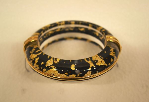Bracciale in acrilico e argento dorato                                      realizzato a cerchio rigido bombato in acrilico trasparente con inclusioni  nero e oro, guarnizioni in argento dorato