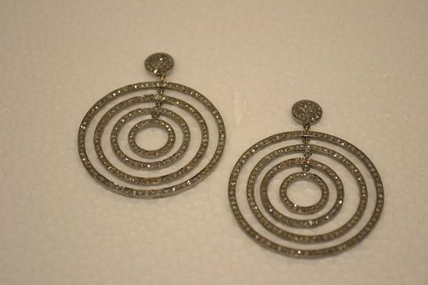 Paio di orecchini pendenti in argento e diamanti                            ciascuno formato da un bottone circolare in pavÃ¨ di brillanti a cui sono    sospesi quattro anelli concentrici anch'essi decorati in brillanti per      complessivi ct 5 circa, g 15                                               (2)