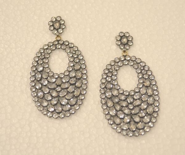 Paio di orecchini pendenti  in argento                                formati da un elemento a corolla a cui Ãž sopseso                            un elemnto ovale entrambi decorati da topazi                                bianchi