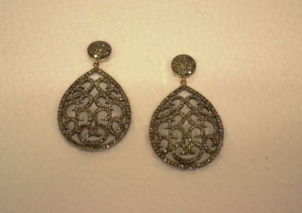 Paio di orecchini pendenti in argento con                            elemento a bottone circolare a cui Ãž sospeso un                             elemento a goccia traforata a volute entrambi                               decorati in brillanti per ct 3,06                                          (2)
