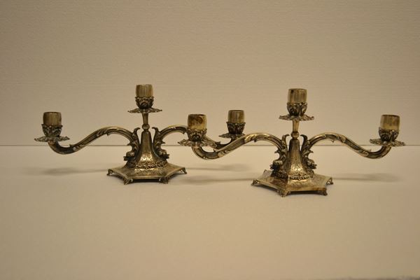 Coppia di candelabri a tre luci ciascuno, in argen                          to inciso, g 1250                                                                                                                                      (2)