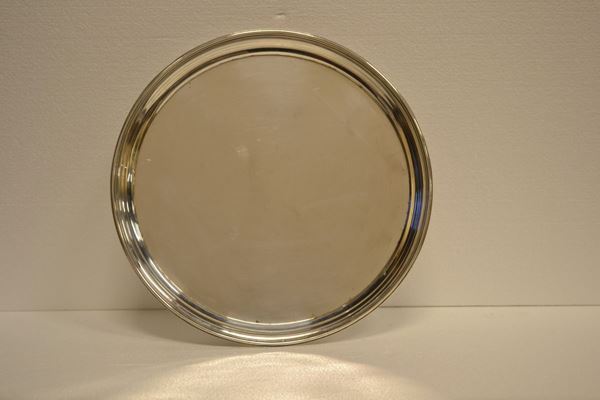 Vassoio, sec. XX, in argento 900, di forma circolare poggiante su quattro   piedini modellati a volute fogliacee, diam. cm 35, g 1090