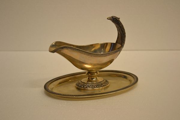 Salsiera, sec. XX, in argento con presa modellata a testa di aquila e bordo del vassoietto                                                              cesellato a foglie, g 480