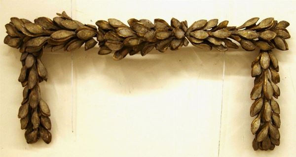 Ghirlanda sec. XVIII, in legno intagliato, dipinto in bianco ed in parte dorato, modellata come un elemento orizzontale a piccole foglie con due tralci verticali ricadenti, cm 140x66, danni e mancanze