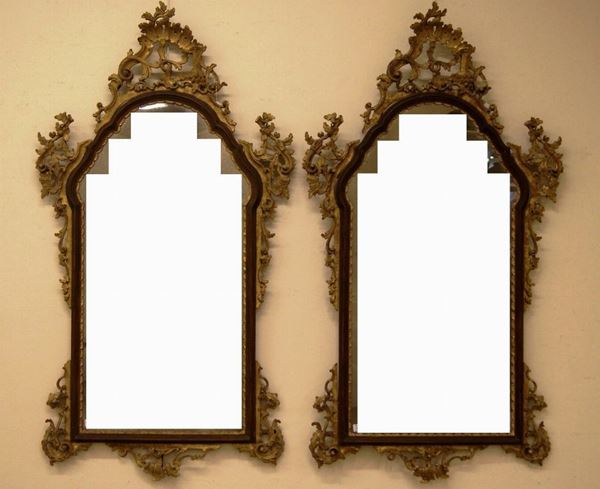 Coppia di specchiere, Veneto sec. XIX, in stile Settecento, in noce e legno intagliato e dorato, alta cimasa traforata a motivi rocaille con festoni di fiori e foglie di quercia ricadenti lateralmente, cornice sagomata, piedi a voluta, cm 151x85, specchi sostituiti, danni e mancanze (2)