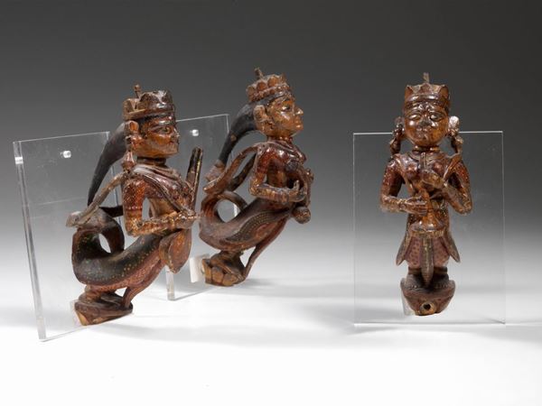 Tre piccole sculture in legno, sudest asiatico, XX secolo, raffiguranti     musici con gli strumenti sorretti all'altezza del petto, dipinte a           policromia e in pose aggettanti (3)