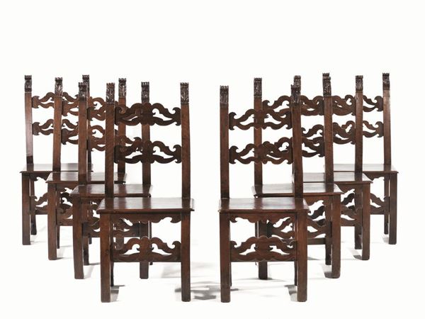 Otto sedie, Italia settentrionale, seconda metÃ  sec. XVII, in noce          intagliato a patina scura, finali a fiamma, doppia cartella a volute        contrapposte, gambe rettilinee, complete di cuscini in velluto rosso,       alcuni restauri (8)