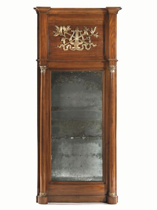 Specchiera, Toscana, inizi sec. XIX, in ciliegio, alta cimasa rettangolare  centrata da composizione di strumenti musicali, specchio rettangolare tra   colonne su basi e capitelli dorati, basamento rettilineo, cm 193x90