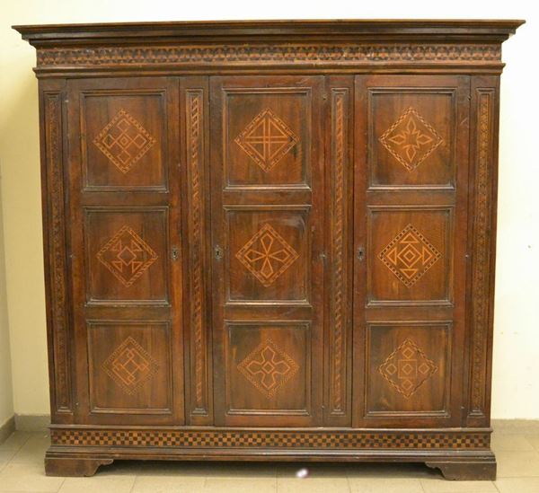 Armadio, inizi sec XX, in noce intarsiato a tre sportelli, piedi a mensola, cm 200x60x188