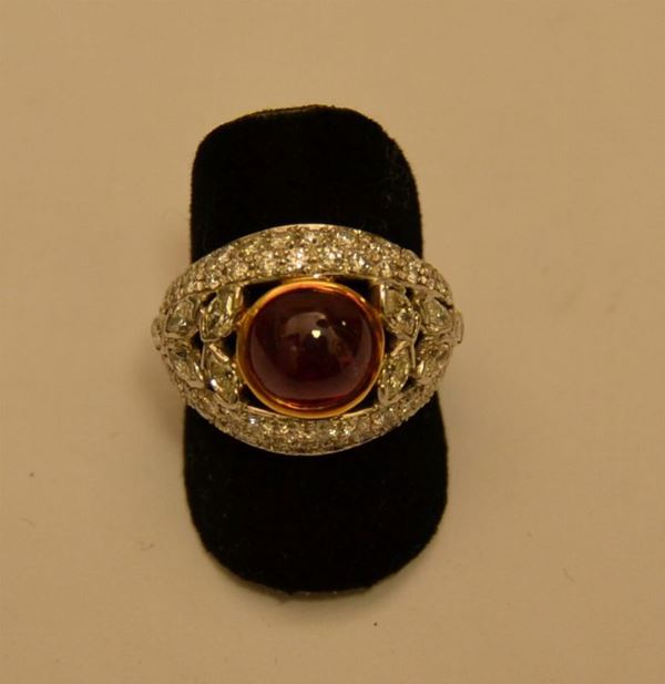 Anello, in oro bianco e giallo, con rubino centrale cabouchon e pavÃ¨ di brillanti di vari tagli, g 7,2, marcato Torrini