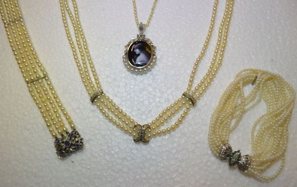 Collana girocollo in perle oro bianco e diamanti                            a tre fili di piccole perle con inserti in oro e piccoli brillanti;         Bracciale in microperle, oro bianco, diamanti e smeraldi                    a dodici fili di microperle, fermatura in oro bianco smeraldi e piccoli     diamanti;                                                                   Bracciale in perle di fiume, oro bianco e zaffiri                           a quattro fili di piccole perle, fermatura traforata e cesellata a piccole  foglie decorate da zaffiri                                                  Collana in perle con pendente in smalti, oro bianco, perle e diamanti       realizzata ad un filo di piccole perle, pendente ovale formato da una       placca in smalti di Limoges decorata a profilo muliebre e montata entro     cornice in oro bianco, perle e piccoli brillanti di taglio vecchio (5)