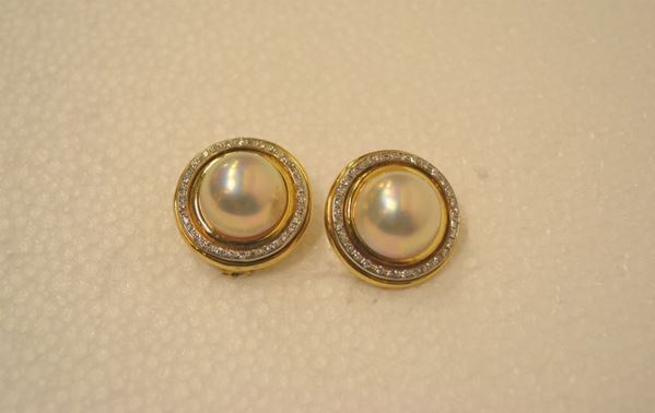 Paio di orecchini in oro giallo, perle mabÃ¨ e diamanti                      ciascuno formato da una perla mabÃ¨ montata entro castone circolare decorato da una fila di brillanti, g 22                         (2)