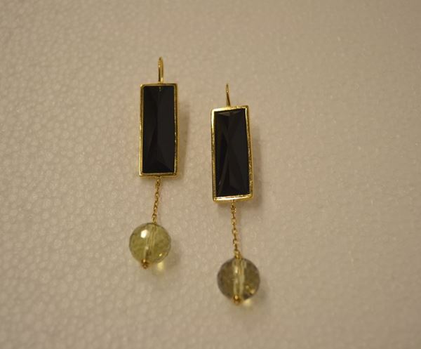 Paio di orecchini pendenti in oro giallo, onice e quarzo                    ciascuno realizzato con un onice rettangolare montato in oro giallo con     monachella a cui Ã¨ sospesa tramite una catenella in oro giallo una sfera    briolettata in quarzo citrino, g 20                                        (2)