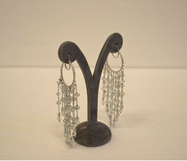 Paio di orecchini pendenti in oro bianco ed acquamarine                     ciascuno realizzato con un cerchio cesellato a cui Ã¨ sospesa un frangia     formata da undici catenelle a maglia sottile lungo cui si intercalano       acquamarine a sferetta schiacciata e a goccia, g 26                        (2)