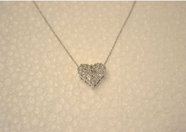 Pendente in oro bianco e diamanti                                           realizzato come un cuore in pavÃ¨ di brillanti per ct 0,50 circa,completo di catena a maglia sottile in oro bianco