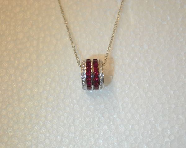 Pendente in oro bianco, rubini e diamanti                                   realizzato come un anello decorato da due linee di rubini carrÃ¨ per ct 2,30 circa e brillanti per ct 0,30 circa, completo di catena a maglia