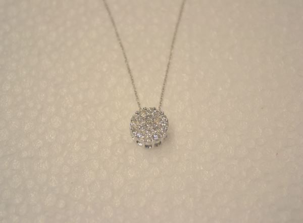 Pendente in oro bianco e diamanti                                           realizzato come un piccolo bottone circolare in pavÃ¨ di brillanti per ct    0,46, completo di catena a maglia sottile in oro bianco