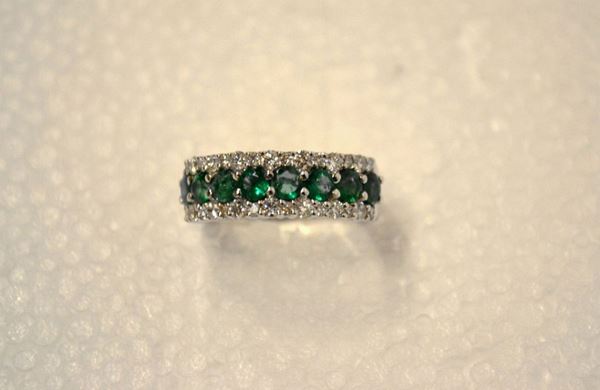 Anello in oro bianco, diamanti e smeraldi                                   fascia decorata da una linea di smeraldi per ct 1 circa fra due linee di    brillanti per ct 0,60 circa, misura 12,5